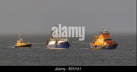 Questa è la base di Buckie barca da pesca, Ranger OB29 trainato indietro nel porto di Buckie martedì 20 novembre 2018 dall'Buckie scialuppa di salvataggio. Foto Stock