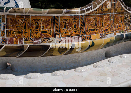 Mosaico colourful disegni sul retro di panche progettato da Antoni Gaudi presso il Parco Guell, Barcellona, Spagna Foto Stock