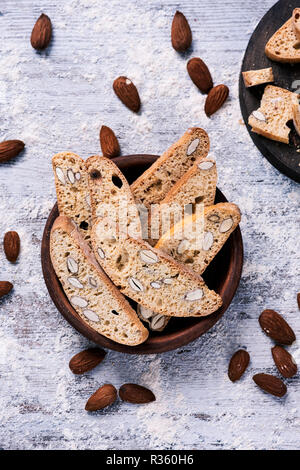 Angolo di alta vista di alcuni carquinyolis, dolci tipici della Catalogna, Spagna, fatta con le mandorle, il grigio di una tavola in legno rustico Foto Stock