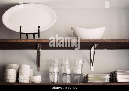 Mensola da cucina con piatti, ciotole e tazze Foto Stock