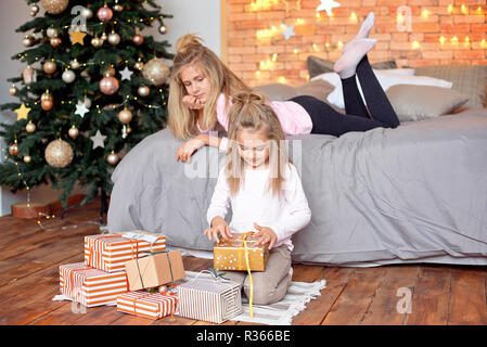 Buon Natale e Buone Feste. Allegro carino bambini doni di apertura. Bambini il divertimento nelle vicinanze del Tree al mattino. Famiglia amorevole con presenta in roo Foto Stock