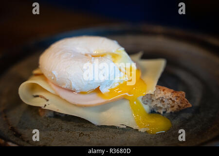 Tutto il grano di pane tostato con formaggio, prosciutto e uovo affogato. Foto Stock