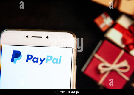 American online piattaforma di pagamento di proprietà di Paypal, il logo è visibile su un androide dispositivo mobile con un Natale regali avvolti in background. Foto Stock