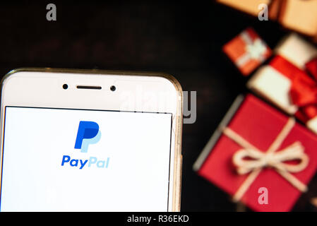 American online piattaforma di pagamento di proprietà di Paypal, il logo è visibile su un androide dispositivo mobile con un Natale regali avvolti in background. Foto Stock