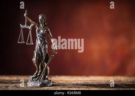 Signora Justicia la spada e scalare la statuetta in bronzo sul tavolo di legno. Foto Stock