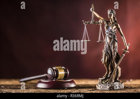 Signora Justicia la spada e scalare la statuetta in bronzo con il giudice martello sul tavolo di legno. Foto Stock