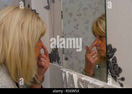 Signor donna con la polka dots sul suo viso Foto Stock