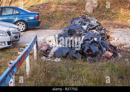 Parcheggio bloccato con sacchetti di plastica contenenti cestino, inquinare l'ambiente. Foto Stock