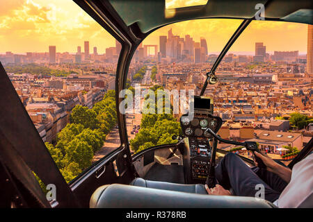 Cockpit in elicottero volando su piazza Charles de Gaulle di Parigi, capitale francese, l'Europa. Volo panoramico sopra lo skyline di Parigi in Francia e d'Europa. Scenic paesaggio urbano e orizzonte parigino sul tramonto. Foto Stock