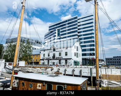 Tromsö city centre, al porto, hotel Clarion 'il bordo", torta a forma di edificio, tradizionale ristorante 'Skarven' , vecchio legno barca a vela, Tromsö, Foto Stock