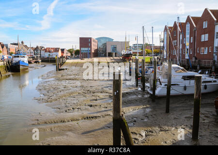 Husum porto interno a bassa marea con scivolo e barche sul mudflat in una giornata di sole sulla costa del mare del Nord in Germania, messa a fuoco selezionata Foto Stock