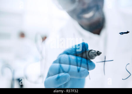 Scienziato scrive la formula su un bordo di vetro Foto Stock