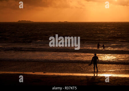 Surfisti in silhouette a Whitesands Bay su Il Pembrokeshire Coast del Galles del Sud Foto Stock