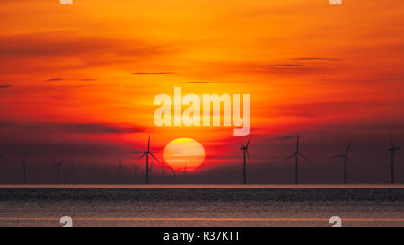 Sulle turbine eoliche offshore a sunrise in Colwyn Bay sulla costa settentrionale del Galles Foto Stock