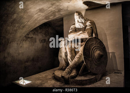 Helsingør, Danimarca — la statua di Holger il danese di Hans Peder Pedersen-Dan si trova nelle casematte sotto il castello di Kronborg, notoriamente associata alla commedia di William Shakespeare Amleto. Secondo la leggenda danese, Holger rimane in sonno, pronto a svegliarsi per proteggere la Danimarca nel momento del bisogno. Il castello di Kronborg, noto anche come castello di Amleto, sorge su un canale strategico tra Danimarca e Svezia che conduce al Mar Baltico. Il castello, costruito alla fine del XVI secolo, occupa il sito di fortificazioni precedenti. Foto Stock