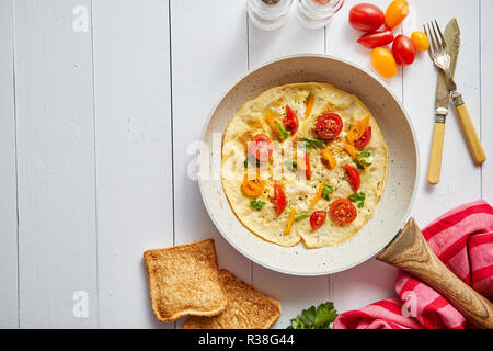 Deliziosa casa frittata di uova con pomodori e prezzemolo Foto Stock