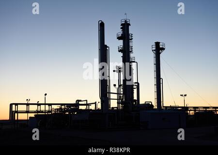 Alba silhouette di tubazioni e torri ad una industria petrolifera e del gas processing facility in Wyoming Foto Stock