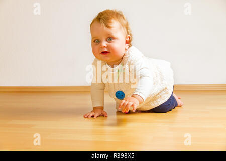 Baby strisciando sul pavimento in legno Foto Stock
