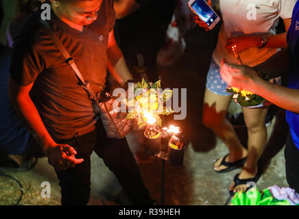 Surin, Thailandia. 22 Novembre, 2018. La gente accende la candela su Krathongs in Surin, Thailandia, nov. 22, 2018. Thailandia osservato l annuale Loy Krathong festival Giovedì. Come una tradizione che è stata seguita per almeno sette secoli, le persone insieme a galla lotus-zattere sagomata adornata con candele, incenso e fiori, noto come Krathongs, attorno alla dodicesima notte di luna piena del calendario tailandese e di augurare a un anno con la sfortuna di essere lavati via dalle acque. Credito: Zhang Keren/Xinhua/Alamy Live News Foto Stock