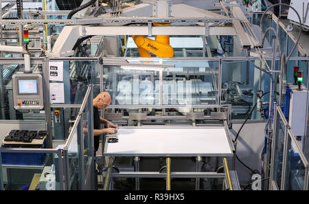 Chemnitz, Germania. 22 Novembre, 2018. Un dipendente di Heckert Solar GmbH lavora in una linea di produzione di moduli solari. L'azienda di famiglia da Sassonia è specializzata nella produzione di alta qualità ed elevate prestazioni di moduli solari. Tra le altre cose, si è sviluppato un modulo nero per trattenuta visivamente l'uso in edifici elencati. A causa del loro basso effetto di abbagliamento, questi moduli sono anche predestinato per uso negli aeroporti e vicino alle autostrade. Credito: Jan Woitas/dpa-Zentralbild/dpa/Alamy Live News Foto Stock