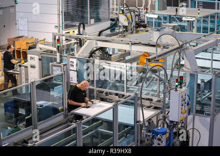 Chemnitz, Germania. 22 Novembre, 2018. Un dipendente di Heckert Solar GmbH lavora in una linea di produzione di moduli solari. L'azienda di famiglia da Sassonia è specializzata nella produzione di alta qualità ed elevate prestazioni di moduli solari. Tra le altre cose, si è sviluppato un modulo nero per trattenuta visivamente l'uso in edifici elencati. A causa del loro basso effetto di abbagliamento, questi moduli sono anche predestinato per uso negli aeroporti e vicino alle autostrade. Credito: Jan Woitas/dpa-Zentralbild/dpa/Alamy Live News Foto Stock