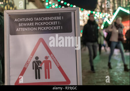 Freiburg, Germania. 22 Novembre, 2018. La gente a piedi passato un segno sull'apertura del mercato di Natale che avverte di borseggiatori. Circa quattro settimane prima di Natale, la stagione dei mercatini di Natale ha cominciato nel Baden-Württemberg. (A lsw: 'Freiburg fa un inizio precoce con il suo mercato di Natale' dal 22.11.2018) Credito: Patrick Seeger/dpa/Alamy Live News Foto Stock