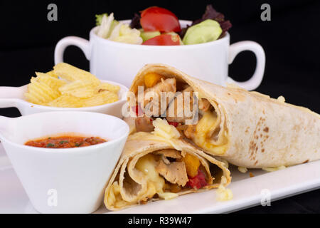 Deliziosi wrap di pollo con insalata all'interno isolato con sfondo nero Foto Stock