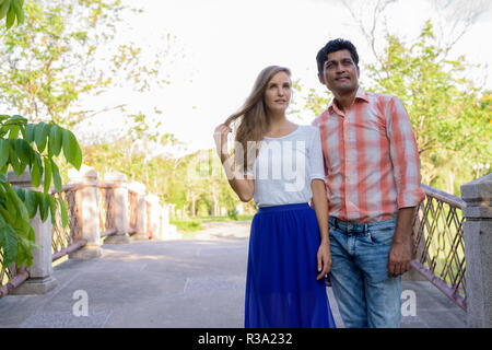 Multi etnico giovane pensare guardando insieme nell'amore o Foto Stock