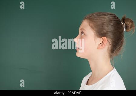 Schoolgirl guarda in alto Foto Stock