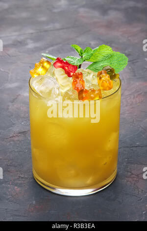 Cocktail per bambini - bevanda a base di arancia con multicolore masticare marmellata worm Foto Stock