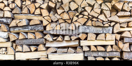 Palo di legno texture. Un trito di legno accatastati in una pila di legno e preparato per il riscaldamento in inverno. Il taglio di legna da ardere per l'inverno. Sfondo di tronchi di legno. Foto Stock