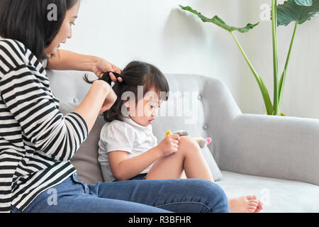 Madre un intreccio di capelli di sua figlia Foto Stock