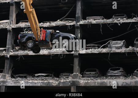 Bruciato auto e altri che guardano integre ma sono stati stornati da compagnie di assicurazione a causa di incendi e danni di acqua sono rimossi dal loro spazi di parcheggio come sono iniziati i lavori di mercoledì a demolire il multi-storey Liverpool Waterfront Parcheggio vicino all'Echo Arena che fu distrutto da un incendio il nuovo YearÕs Eve 2017. Foto Stock