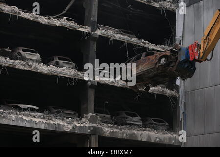 Le auto bruciate vengono rimosse dai loro spazi di parcheggio mentre i lavori iniziarono il mercoledì per demolire il Liverpool Waterfront Car Park a più piani vicino all'Echo Arena, che fu distrutta da un incendio la vigilia di Capodanno 2017. Foto Stock