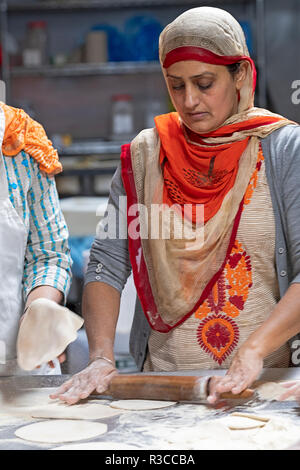 Una donna Sikh volontario, rendere roti di langar, una libera lunchroom comunale in un tempio sikh in Richmond Hill, Queens, a New York City. Foto Stock