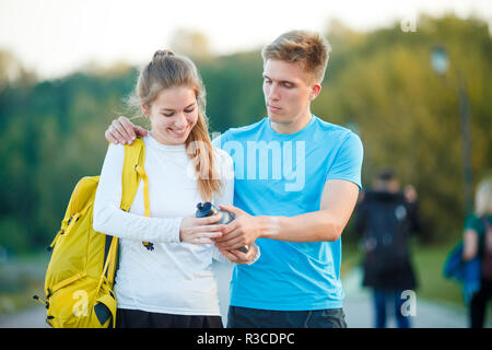 Foto di coppia giovani sportivi guardando orologio nel parco sul giorno di estate Foto Stock