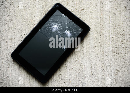Rottura dello schermo tablen vista dall'alto su sfondo di calcestruzzo Foto Stock