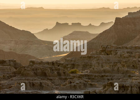 Stati Uniti d'America, Sud Dakota, Badlands NP. Sunrise foschia sopra eroso formazioni. Credito come: Cathy e Gordon Illg Jaynes / Galleria / DanitaDelimont.com Foto Stock