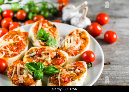 Bruschetta piccante con pomodoro e basilico, tradizionali antipasti italiani Foto Stock