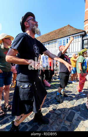 Faversham Hop Festival. I fan del rock francese il gruppo folk, Sur Les Docks, cantare e ballare in corrispondenza della parte anteriore del pubblico durante il concerto. Ore diurne. Foto Stock