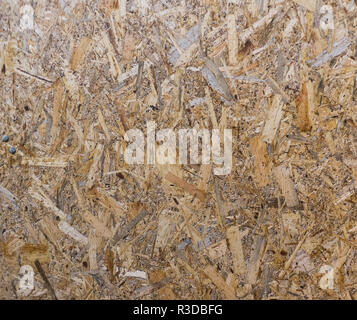 Pannelli OSB sono fatte di marrone da trucioli di legno levigato in uno sfondo di legno. Vista dall'alto di OSB di impiallacciatura di legno sfondo Foto Stock