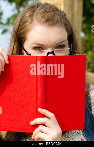 Giovane donna con libro in natura Foto Stock