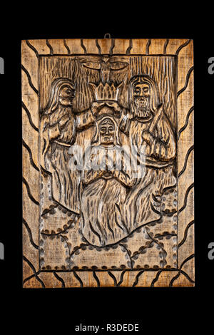 Ingenuo o folk intaglio del legno bassorilievo lapide che rappresenta il biblico Incoronazione della Vergine o di incoronazione di Maria oggetto. Isolato su nero. Foto Stock