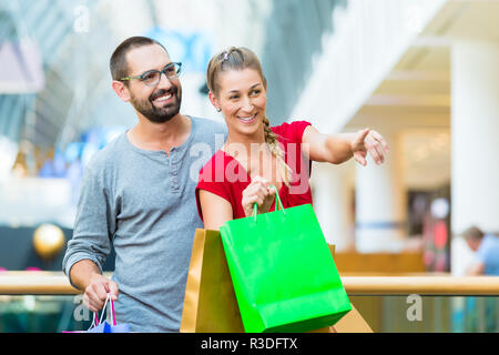 L uomo e la donna nel department store di borse per lo shopping Foto Stock