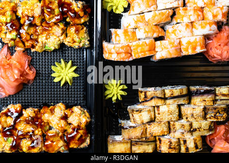 I sushi giapponesi La impostato su sfondo nero. Rotoli di sushi, decapati zenzero, wasabi vista dall'alto. Sfondo di sushi. Asia o il cibo giapponese telaio Foto Stock