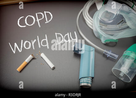 COPD Giornata mondiale scritti in gesso su una lavagna nera accanto a uno stetoscopio e sigaretta, salbutamolo inalatore Foto Stock