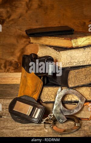 La polizia desk. Libri di leggi e forze di polizia in manette. Inchiesta di criminalità. Pistola e leggi. La legge e l'ordine Foto Stock