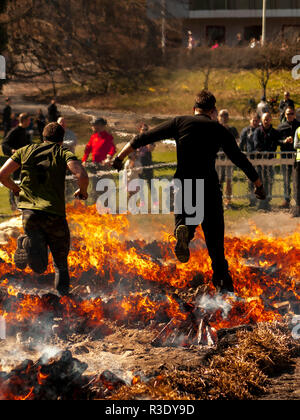 Persone coraggiose che saltano sul fuoco durante la gara di ostacoli Tough Viking a Slottsskogen, Goteborg, Svezia Foto Stock