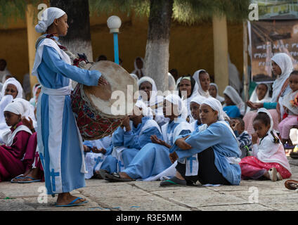 Ragazza etiope suonare il tamburo durante una messa in una chiesa ortodossa, Harari Regione, Harar, Etiopia Foto Stock