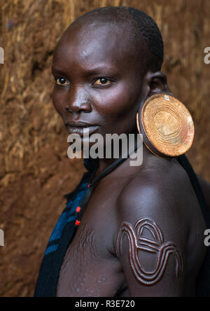 Ritratto di una tribù suri donna con orecchioni allargata ed enormi orecchini, valle dell'Omo, Kibish, Etiopia Foto Stock